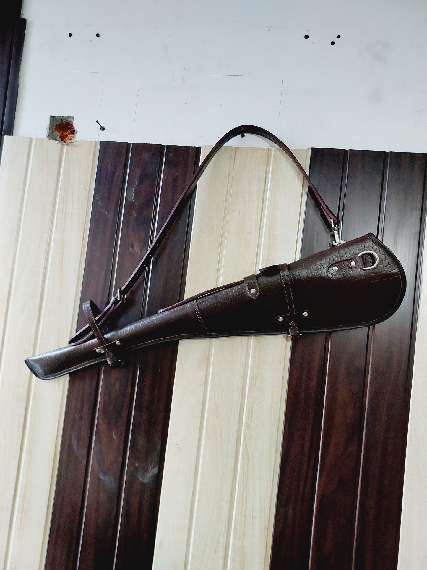 33 inch croc embossed leather rifle scabbard with adjustable strap

Rifle case mounted on wooden wall – western leather design

Inside view of fleece-lined gun scabbard

Full-length view of rifle scabbard with stainless hardware

Leather scabbard displayed on floor – cowboy style

Zoom-in of croc leather pattern with hook and buckle

Hand-holding leather rifle scabbard – easy grip

Informative banner for croc leather scabbard – genuine leather, stainless hardware

Rifle inside scabbard – ammo loop visible