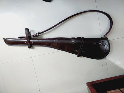 33 inch croc embossed leather rifle scabbard with adjustable strap

Rifle case mounted on wooden wall – western leather design

Inside view of fleece-lined gun scabbard

Full-length view of rifle scabbard with stainless hardware

Leather scabbard displayed on floor – cowboy style

Zoom-in of croc leather pattern with hook and buckle

Hand-holding leather rifle scabbard – easy grip

Informative banner for croc leather scabbard – genuine leather, stainless hardware

Rifle inside scabbard – ammo loop visible