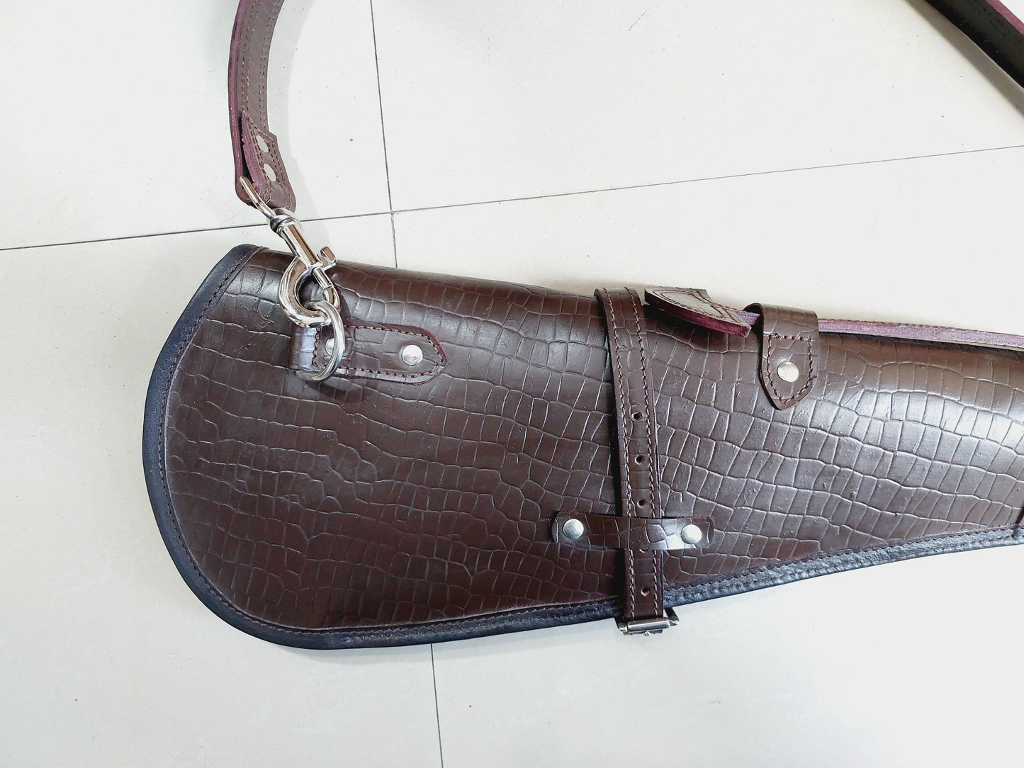 33 inch croc embossed leather rifle scabbard with adjustable strap

Rifle case mounted on wooden wall – western leather design

Inside view of fleece-lined gun scabbard

Full-length view of rifle scabbard with stainless hardware

Leather scabbard displayed on floor – cowboy style

Zoom-in of croc leather pattern with hook and buckle

Hand-holding leather rifle scabbard – easy grip

Informative banner for croc leather scabbard – genuine leather, stainless hardware

Rifle inside scabbard – ammo loop visible